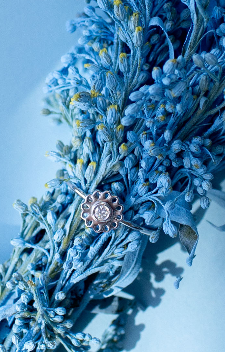 Silver ring with a diamond on blue flowerss